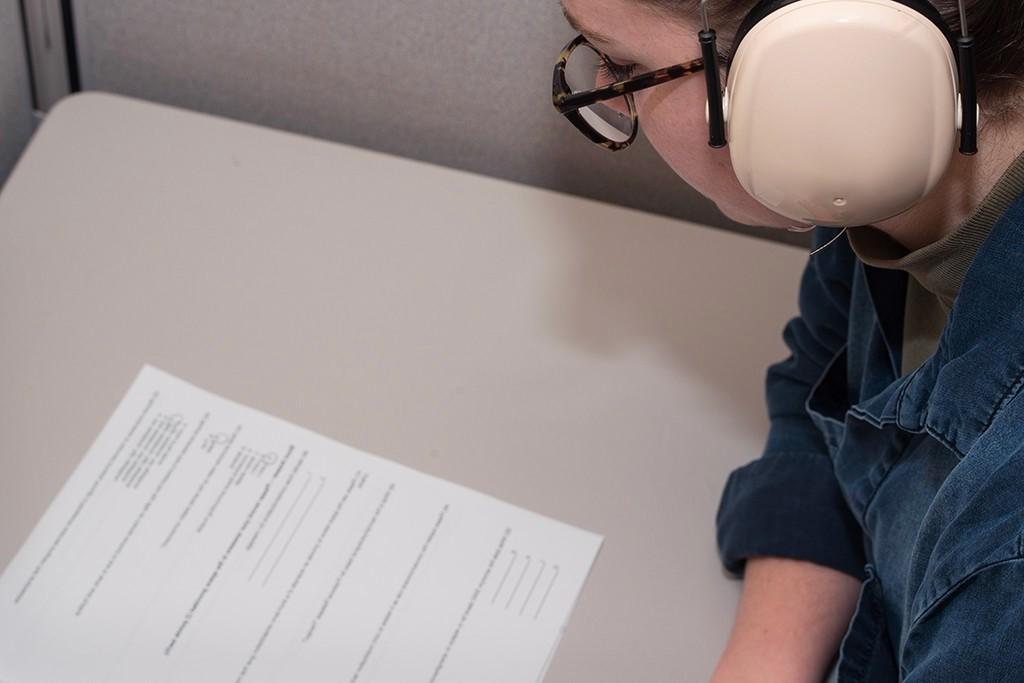 A student wears over-the-ear headphones while taking a test